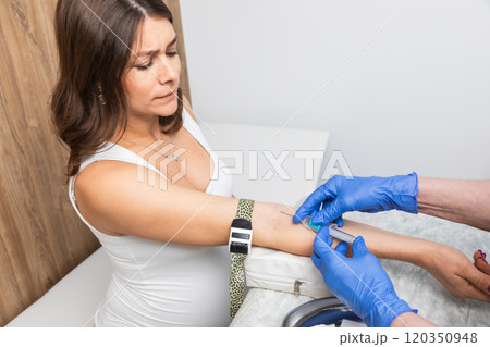 Pregnant woman anxious during blood draw in a clinical setting Pregnant woman anxious during blood draw in a clinical setting 120350948