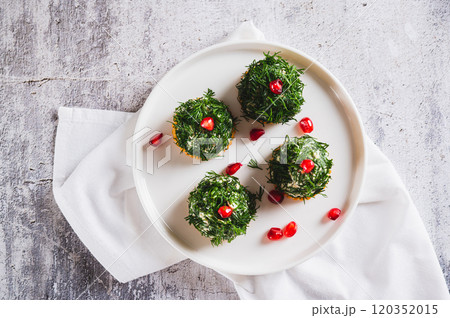 Close up of tuna, egg and dill salad shaped like Christmas trees on crackers on a plate top view 120352015