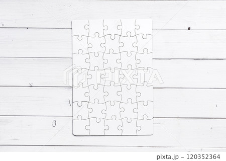 white completed puzzle on wooden table white completed puzzle on wooden table 120352364