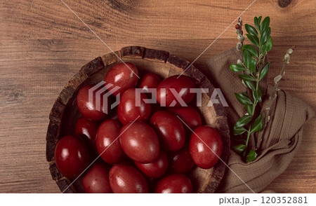 painted eggs in a wooden bowl, red, painted madder dye, powder from the roots of endro, with onion husks, top view, Easter, Georgia, 120352881