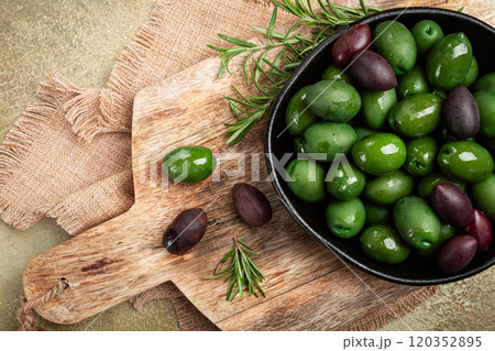 Chalkidiki olives, classic Greek green olives, in a bowl on a cutting board, top view, without people, 120352895