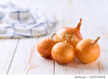 Yellow onions on a wooden table, selective focus. Copy space for text. Yellow onions on a wooden table, selective focus. Copy space for text. 120354048