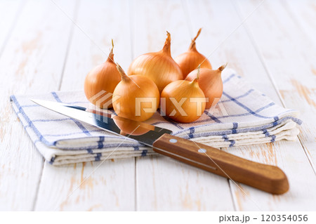 Yellow onions on a wooden table, selective focus. Copy space for text. 120354056