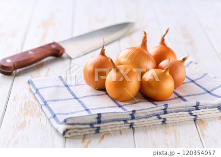 Organic yellow onions on a wooden table, selective focus. Organic yellow onions on a wooden table, selective focus. 120354057
