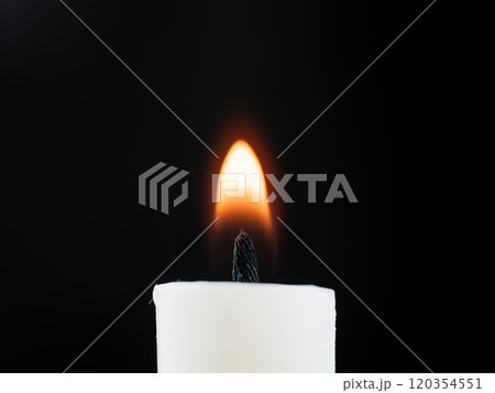 A bright white candle glows in the dark. High quality photo 120354551