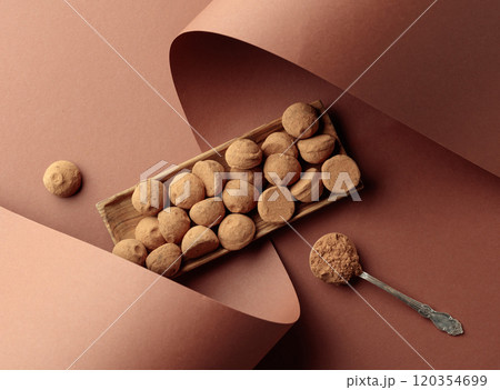 Chocolate truffles and spoon with cocoa powder. 120354699