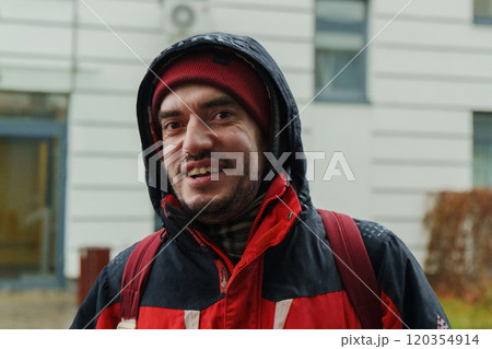 On a crisp day, a man in a red jacket stands outdoors, beaming with joy against the backdrop of contemporary architecture On a crisp day, a man in a red jacket stands outdoors, beaming with joy against the backdrop of contemporary architecture 120354914