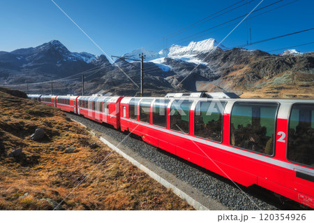 Red train is moving along railway in swiss alps mountain. Autumn Red train is moving along railway in swiss alps mountain. Autumn 120354926