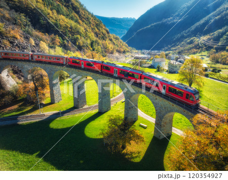 Aerial view of red train on Kreisviadukt Brusio in mountains Aerial view of red train on Kreisviadukt Brusio in mountains 120354927