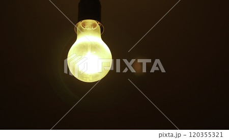 An Illuminated Light Bulb Set Against a Dark Background Creating a Striking Visual Contrast. Stock Clip 120355321