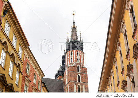 Old cozy European streets in the center of Krakow. Tourists walk around the ancient city and enjoy the architecture in Poland. Old cozy European streets in the center of Krakow. Tourists walk around the ancient city and enjoy the architecture in Poland. 120356233