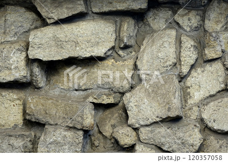 Stone wall made of natural pieces of stones with a crack along gray cement ties 120357058