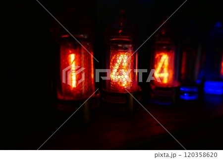 Retro Nixie lamp indicator clock on dark background. The Nixie tube indicator of the numbers of retro style. Retro Nixie lamp indicator clock on dark background. The Nixie tube indicator of the numbers of retro style. 120358620
