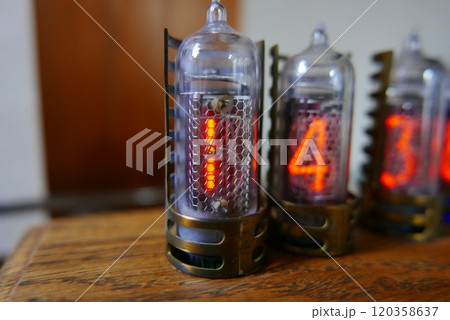 Retro Nixie lamp indicator clock on dark background. The Nixie tube indicator of the numbers of retro style. Retro Nixie lamp indicator clock on dark background. The Nixie tube indicator of the numbers of retro style. 120358637