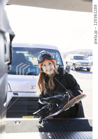 車のトランクからスノーボードを出す若い女性 ウィンタースポーツ 車のトランクからスノーボードを出す若い女性 ウィンタースポーツ 120361289