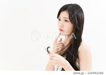 ヘアケアで枝毛を気にする若い女性 120362288