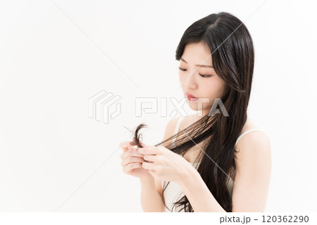 ヘアケアで枝毛を気にする若い女性 ヘアケアで枝毛を気にする若い女性 120362290