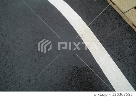 アスファルト道路の濡れた白いライン 120362553