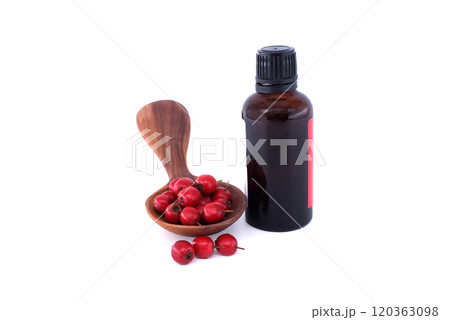 Hawthorn berries and essential oil bottle with wooden spoon isolated on white background 120363098