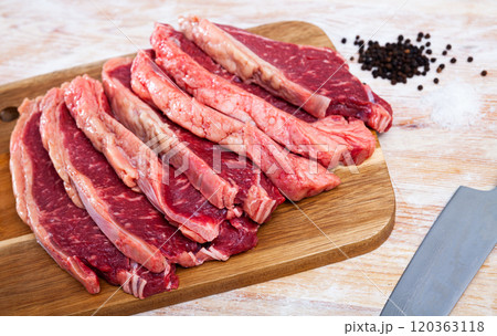 Raw marbled beef steaks with condiments on wooden table 120363118