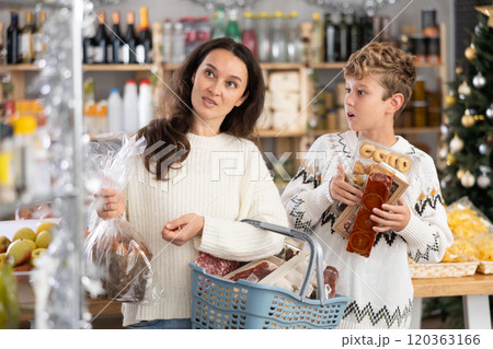 Mother and her son choose different products together for Christmas celebration in grocery supermarket Mother and her son choose different products together for Christmas celebration in grocery supermarket 120363166