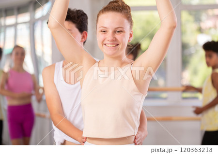 Teenage girl practicing ballet positions in pair with boy in dance studio Teenage girl practicing ballet positions in pair with boy in dance studio 120363218
