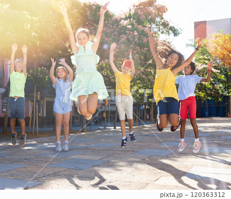 Group of cheerful young girls and boys jumping together 120363312
