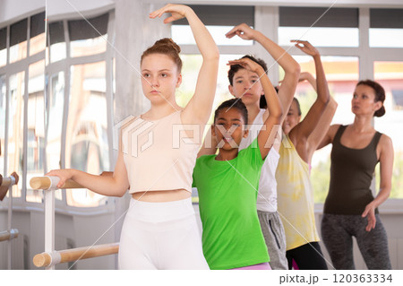 Teenage girl practicing ballet positions in dance studio 120363334