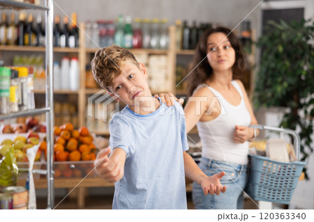 Teen boy quarrels with mother while shopping, he gets angry and turns away from mother Teen boy quarrels with mother while shopping, he gets angry and turns away from mother 120363340