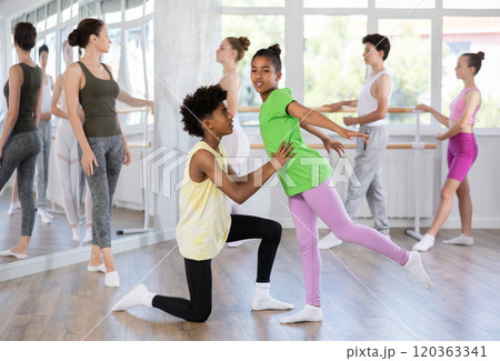 Teenage boy and girl doing together arabesque position of ballet during choreography classes Teenage boy and girl doing together arabesque position of ballet during choreography classes 120363341