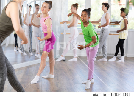 Teenage African American girl practicing ballet moves at group class 120363391
