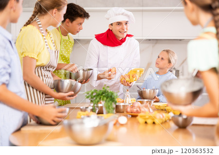 At cooking course, man cook with egg tray in hands tells children about cooking fluffy pancakes At cooking course, man cook with egg tray in hands tells children about cooking fluffy pancakes 120363532