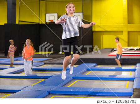 Tween girl having fun jumping in indoor trampoline arena 120363703