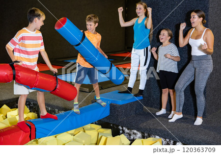 Active excited childschool boys fighting with inflatable logs in game center Active excited childschool boys fighting with inflatable logs in game center 120363709
