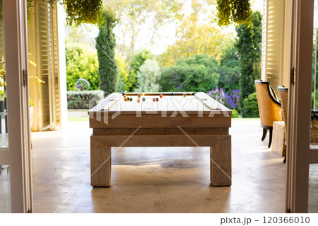 Playing billiards on pool table in bright, open indoor-outdoor space Playing billiards on pool table in bright, open indoor-outdoor space 120366010
