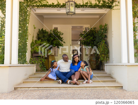 Sitting on porch steps, family of four with daughters enjoying quality time together Sitting on porch steps, family of four with daughters enjoying quality time together 120366065