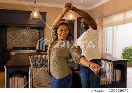 Dancing together in kitchen, multiracial couple enjoying quality time at home Dancing together in kitchen, multiracial couple enjoying quality time at home 120366073