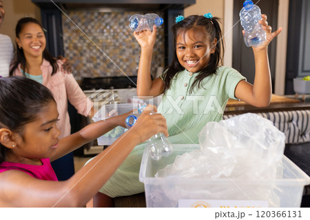 Recycling plastic bottles, children smiling and helping in kitchen with family 120366131