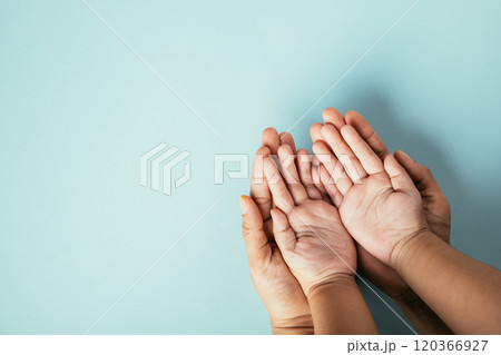 Close-up top view of family hands stack isolated background. Parents and kid hold empty space symbolizing support and love on Family and Parents Day. Close-up top view of family hands stack isolated background. Parents and kid hold empty space symbolizing support and love on Family and Parents Day. 120366927