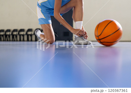Tying shoelaces, female basketball player preparing for game on court, copy space 120367361