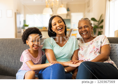 Smiling multigenerational family sitting on couch, enjoying quality time together Smiling multigenerational family sitting on couch, enjoying quality time together 120367569
