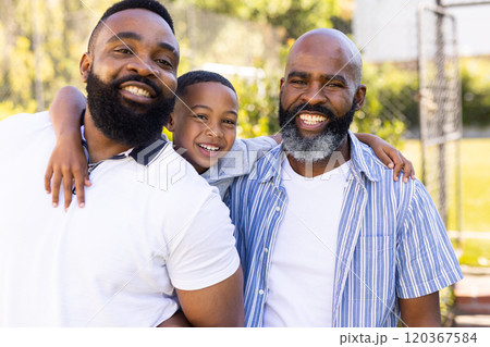 Hugging father and grandfather, smiling boy enjoying time with family outdoors 120367584