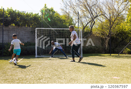 Playing soccer outdoors, grandparents and grandson enjoying time together on sunny day Playing soccer outdoors, grandparents and grandson enjoying time together on sunny day 120367597