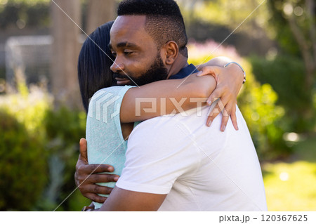 Hugging each other, man and woman sharing comforting moment outdoors 120367625