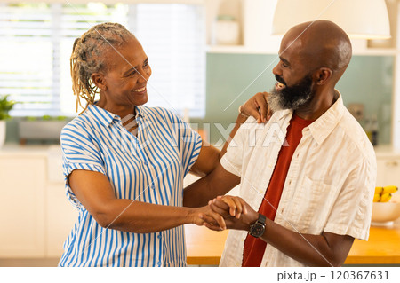 Smiling couple holding hands and enjoying time together in kitchen at home Smiling couple holding hands and enjoying time together in kitchen at home 120367631