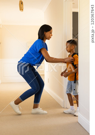Helping child with backpack, woman preparing boy for school in hallway Helping child with backpack, woman preparing boy for school in hallway 120367643