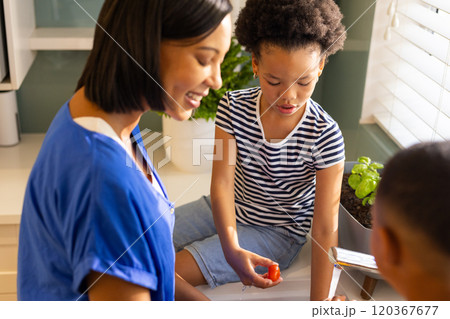 Mother and children in kitchen preparing healthy meal with fresh vegetables 120367677