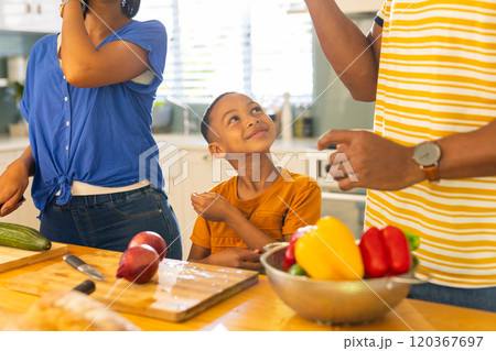 Preparing vegetables in kitchen, family cooking together, smiling child watching Preparing vegetables in kitchen, family cooking together, smiling child watching 120367697