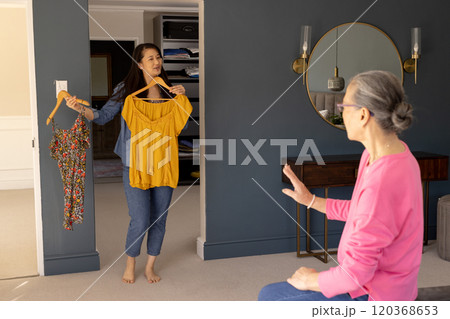 Choosing outfits, asian woman showing clothes to elderly grandmother in bedroom 120368653
