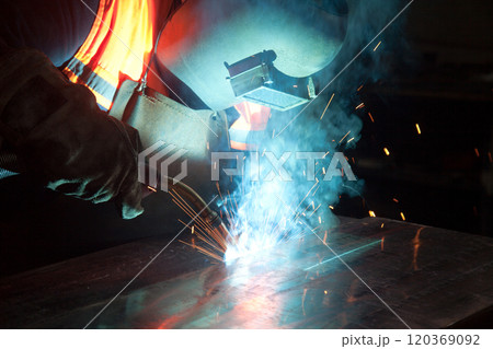 Welder uses torch to make sparks during manufacture of metal equipment, industrial professional worker Welder uses torch to make sparks during manufacture of metal equipment, industrial professional worker 120369092